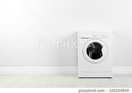 Modern washing machine near white wall, space for text. Laundry day 108204640
