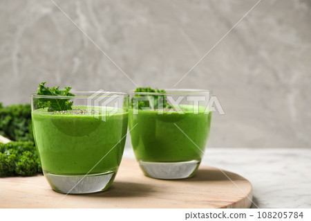 Tasty kale smoothie on marble table, closeup Tasty kale smoothie on marble table, closeup 108205784