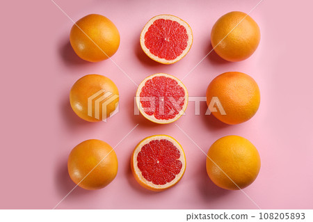 Cut and whole ripe grapefruits on pink background, flat lay Cut and whole ripe grapefruits on pink background, flat lay 108205893