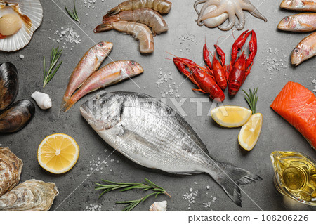 Fresh fish and seafood on grey table, flat lay Fresh fish and seafood on grey table, flat lay 108206226