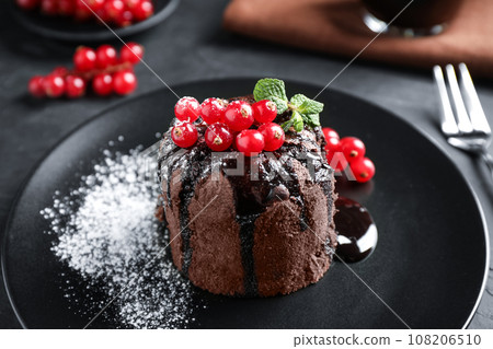 Delicious warm chocolate lava cake with mint and berries on table, closeup Delicious warm chocolate lava cake with mint and berries on table, closeup 108206510