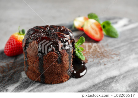 Delicious warm chocolate lava cake on marble board, closeup Delicious warm chocolate lava cake on marble board, closeup 108206517