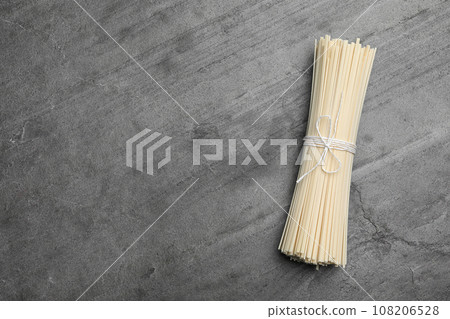 Raw rice noodles on grey table, top view. Space for text Raw rice noodles on grey table, top view. Space for text 108206528