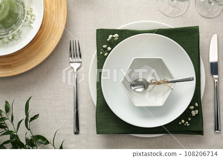 Elegant table setting with green plants on light cloth, flat lay Elegant table setting with green plants on light cloth, flat lay 108206714