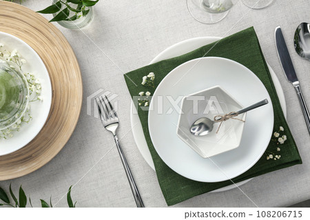 Elegant table setting with green plants on light cloth, flat lay Elegant table setting with green plants on light cloth, flat lay 108206715