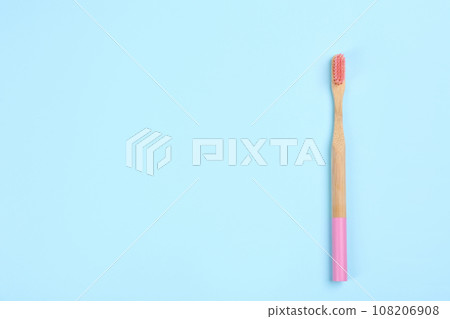 Toothbrush made of bamboo on light blue background, top view. Space for text Toothbrush made of bamboo on light blue background, top view. Space for text 108206908
