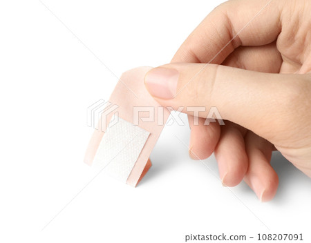 Woman putting sticking plaster on white background. First aid item Woman putting sticking plaster on white background. First aid item 108207091