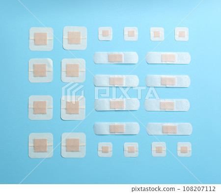 Different types of sticking plasters on light blue background, flat lay Different types of sticking plasters on light blue background, flat lay 108207112