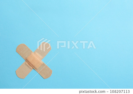 Sticking plasters on light blue background, top view. Space for text 108207113
