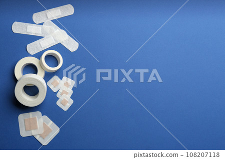 Different types of sticking plasters on blue background, flat lay. Space for text Different types of sticking plasters on blue background, flat lay. Space for text 108207118