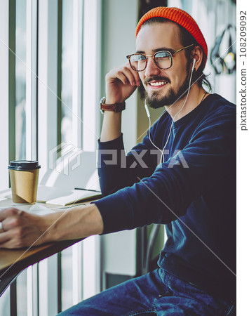 happy man in eyewear looking away and smiling during music hobby happy man in eyewear looking away and smiling during music hobby 108209092