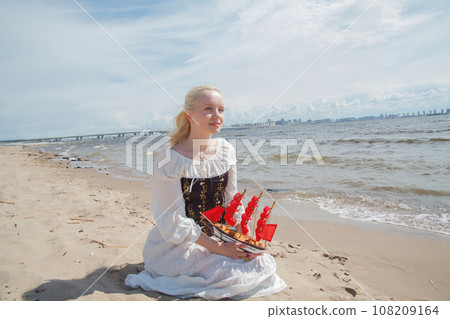 Young pretty woman sitting on sea beach 108209164