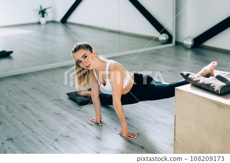 Female gymnast stretching legs with box 108209173