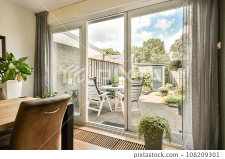 a dining room with sliding glass doors that open up to the patio and backyard area, as seen from outside 108209301
