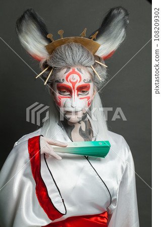 Actress woman with animal makeup, mask and stage asian costume posing on black background.  108209302