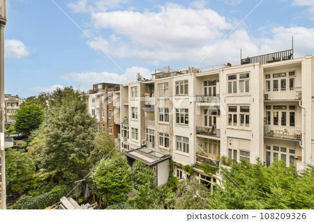 an apartment complex with trees and buildings in the fore -ground area, taken from a high angle on a sunny day an apartment complex with trees and buildings in the fore -ground area, taken from a high angle on a sunny day 108209326