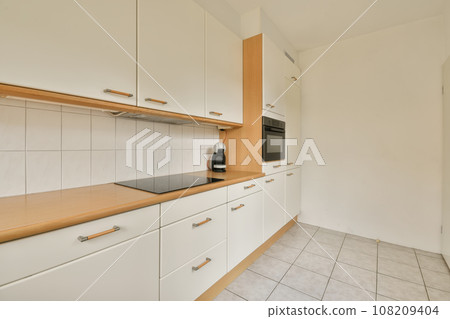 a kitchen with white cupboards and wood counter tops on the counters in this photo is taken from the inside 108209404