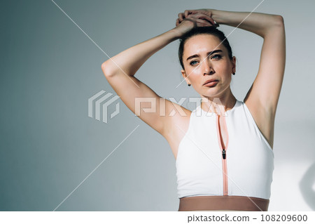 Focused woman preparing hairstyle for training Focused woman preparing hairstyle for training 108209600