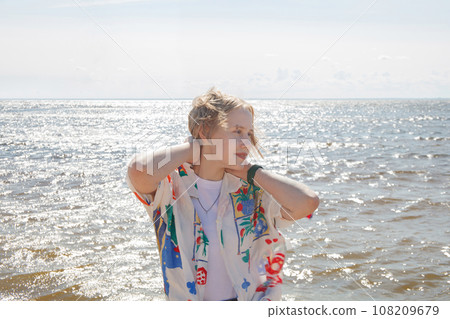 Happy pretty young blonde woman with short bob haircut outdoor portrait 108209679