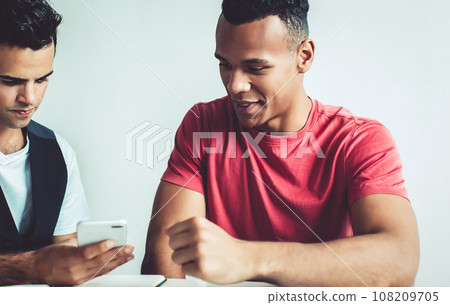 millennial men checking email via cellphone 108209705