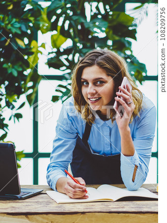 smiling woman calling for planning organisation in shop smiling woman calling for planning organisation in shop 108209756