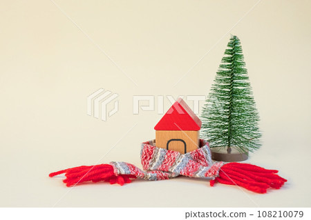 Christmas Tree in a Scarf. Creativity Image of Cold Season. Heating System, Winter is Coming Creative Concept. Model of a House Wearing a Knitted Warm Clothes. Electricity and Gas Price Rising Christmas Tree in a Scarf. Creativity Image of Cold Season. Heating System, Winter is Coming Creative Concept. Model of a House Wearing a Knitted Warm Clothes. Electricity and Gas Price Rising 108210079