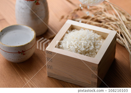 方形木紋背景中的熱清酒(白米)米 方形木紋背景中的熱清酒(白米)米 108210103