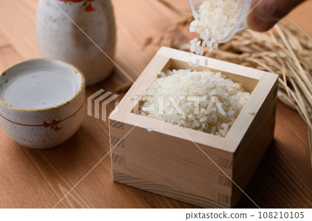 方形木紋背景中的熱清酒(白米)米 方形木紋背景中的熱清酒(白米)米 108210105