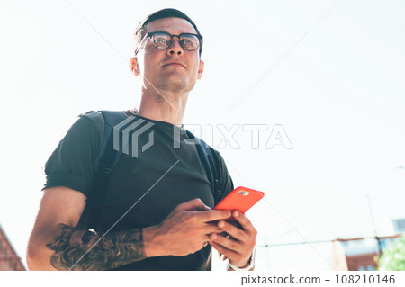 Thoughtful young man in spectacles for vision correction pondering looking away  108210146