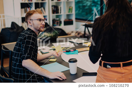 Young coworkers discussing projects in office 108210270