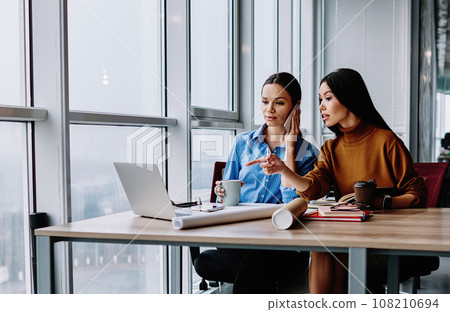 Female colleagues having working process and cooperation using modern technology for research 108210694