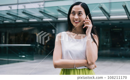 Beautiful Asian woman talking on phone 108211170
