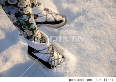 A woman walks on a thick layer of fresh snow. A woman walks on a thick layer of fresh snow. 108211274