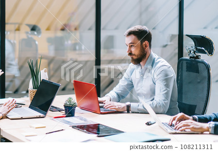 Concentrated businesspeople collaborating in bright office Concentrated businesspeople collaborating in bright office 108211311