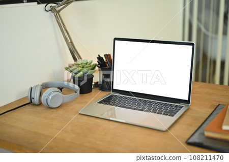 Creative workplace with laptop, headphone, plant and stationery on wooden table 108211470