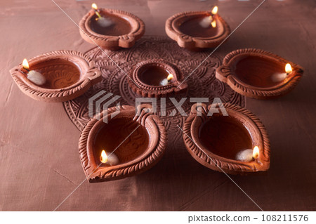 Burning diya on Happy Diwali, background for light festival of India Burning diya on Happy Diwali, background for light festival of India 108211576