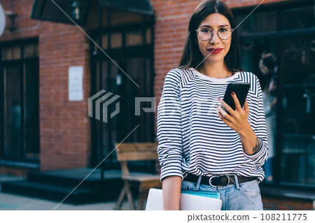 Half length portrait of successful female graphic designer holding laptop computer for distance job Half length portrait of successful female graphic designer holding laptop computer for distance job 108211775