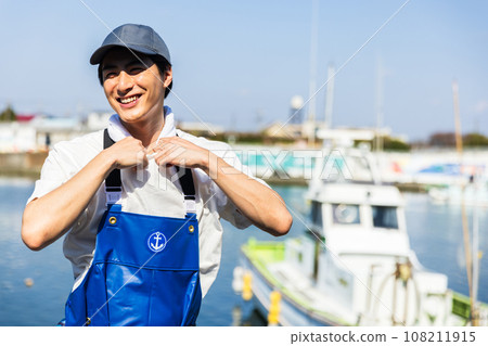 A young fisherman working at a fishing port 108211915