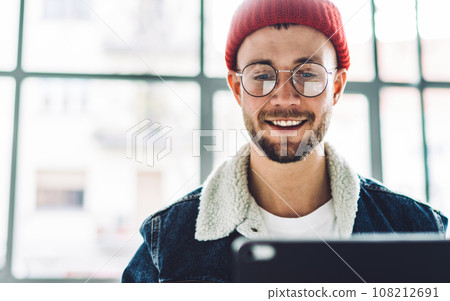 Cheerful young male chatting with digital tablet 108212691