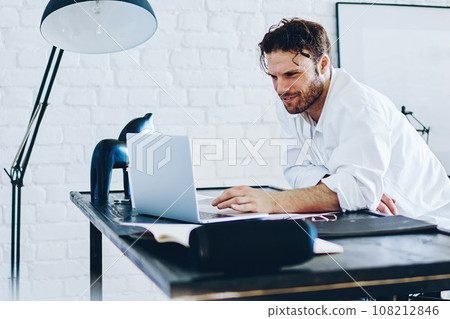 Serious male freelancer checking publication in blog on laptop computer working remotely 108212846