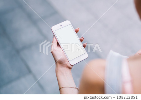 Woman surfing on smartphone in street 108212851