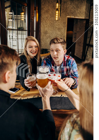 Happy group of friends drinking and clinking with beer and cocktails at brewery bar restaurant 108213009