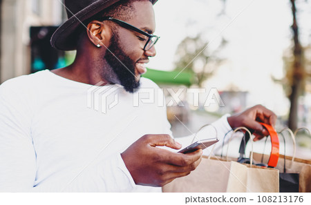 cheerful african american male happy about online buying with discount 108213176