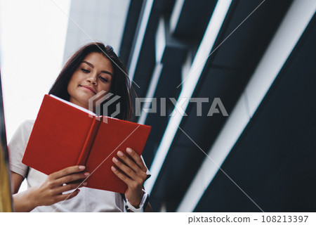 attractive young hipster girl satisfied with best seller spending time on hobby on urban setting 108213397