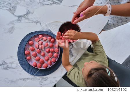 Grandmother and granddaughter preparing meatballs. Grandmother and granddaughter preparing meatballs. 108214102