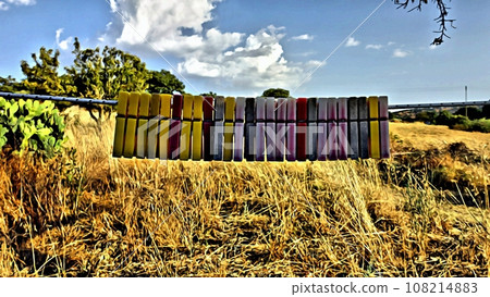 A group of clothes pegs hanging on the string in the garden. 108214883