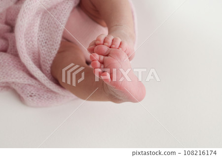 Close-up of tiny, cute, bare toes, heels and feet of a newborn girl, boy. Baby foot on pink soft coverlet, blanket. Detail of a newborn baby legs. Macro horizontal professional studio photo. Close-up of tiny, cute, bare toes, heels and feet of a newborn girl, boy. Baby foot on pink soft coverlet, blanket. Detail of a newborn baby legs. Macro horizontal professional studio photo. 108216174
