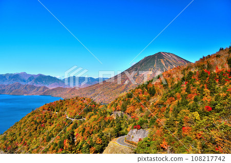 Nikko City, Tochigi Prefecture: Mt. Nantai, Lake Chuzenji, and Lake Chuzenji skyline dyed in autumn leaves 108217742