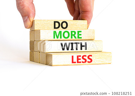 Do more with less symbol. Concept word Do more with less on beautiful wooden block. Beautiful white table white background. Businessman hand. Business do more with less concept. Copy space. 108218251