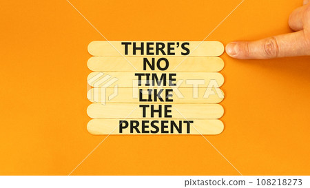 Present time symbol. Concept words There is no time like the present on wooden stick. Beautiful orange table orange background. Businessman hand. Business Present time concept. Copy space. 108218273